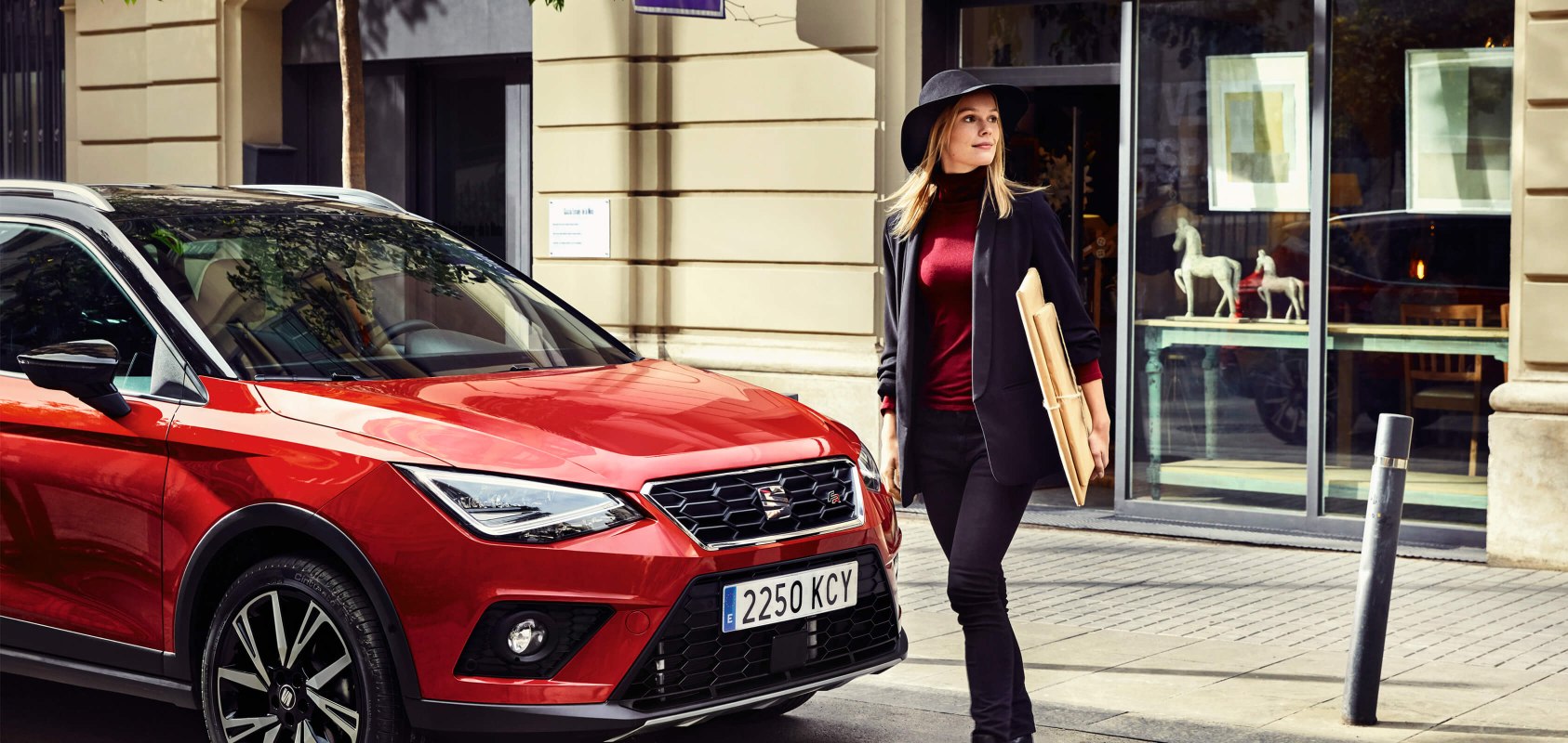 SEAT new car services maintenance mot checks –  woman walking in front of a red SEAT Arona crossover SUV