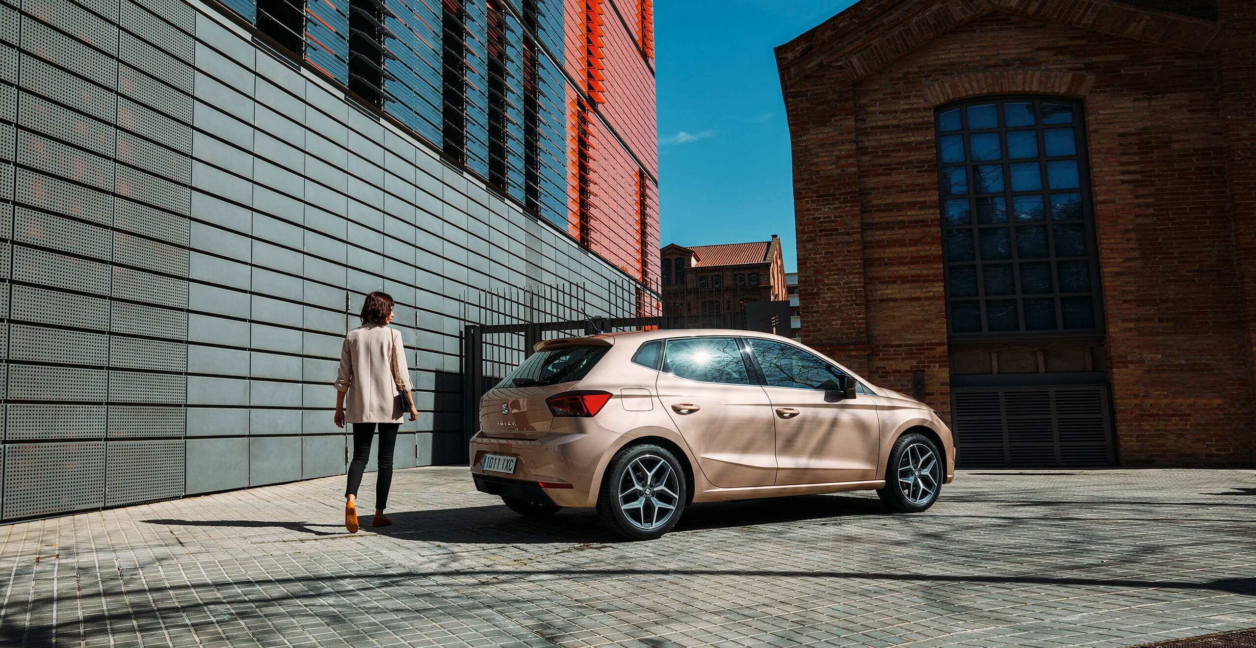 SEAT car servicing and maintenance accident specialists safety – woman standing beside a parked SEAT Ibiza hatchback city car