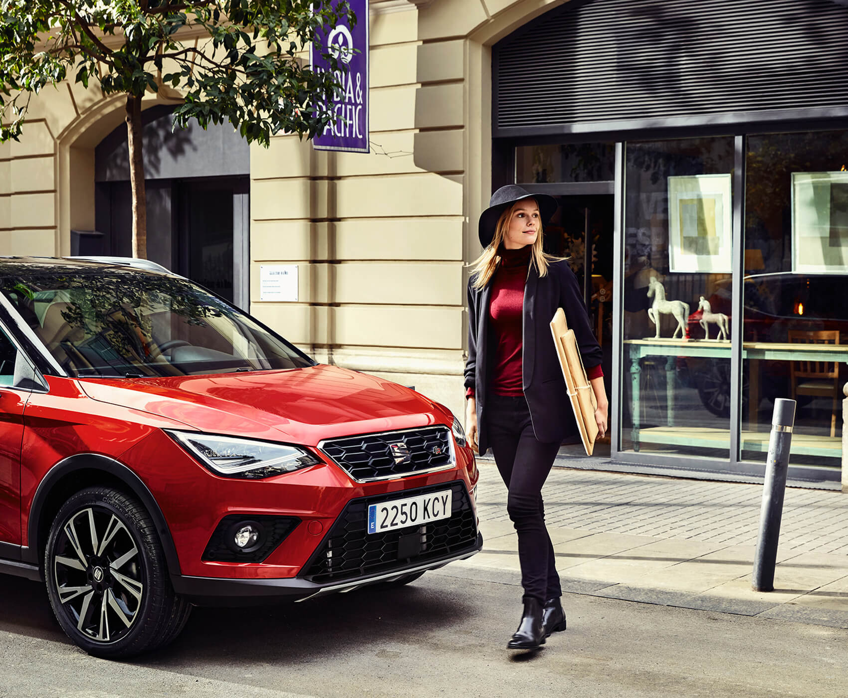 SEAT new car services maintenance mot checks –  woman walking in front of a red SEAT Arona crossover SUV
