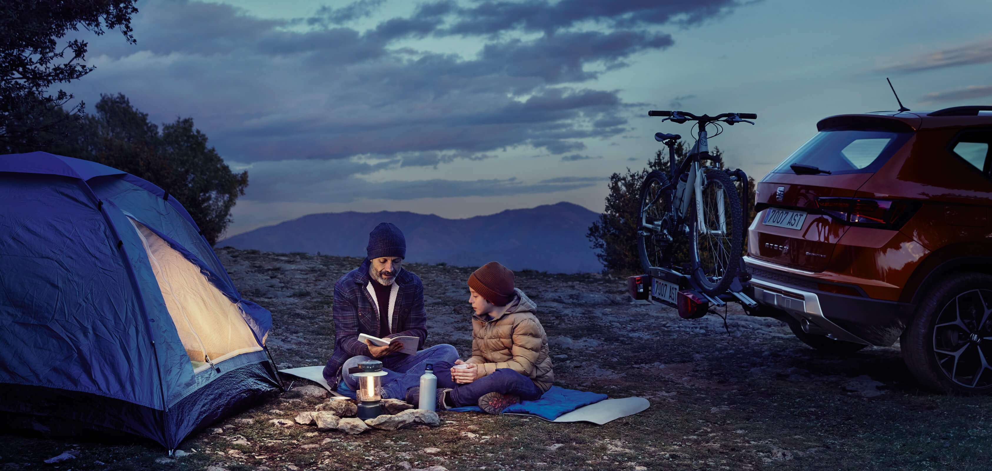 SEAT new car services and maintenance – SEAT Arona crossover SUV parked overlooking a valey with man leaning on the car