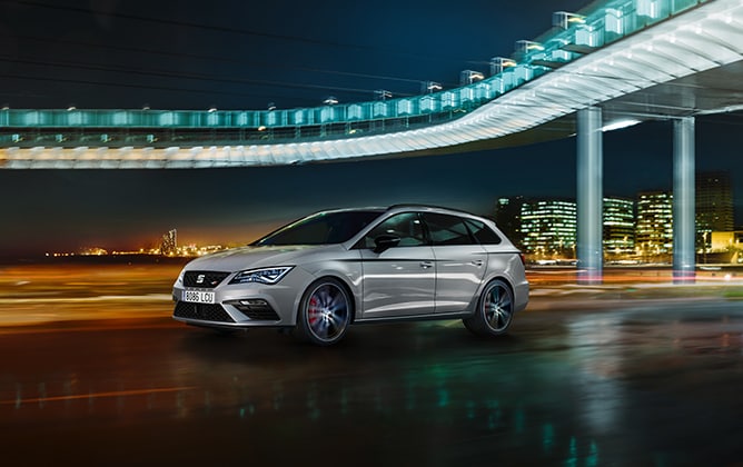 SEAT León CUPRA in a night scene with the illuminated city behind